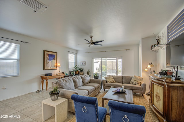 living area with light tile patterned floors, baseboards, visible vents, and a ceiling fan