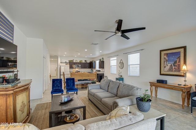 living area featuring light tile patterned floors, visible vents, a ceiling fan, and recessed lighting