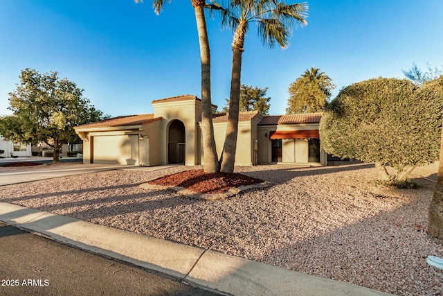 mediterranean / spanish-style house with a garage