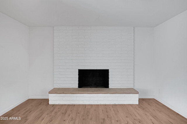 details featuring a brick fireplace and wood-type flooring