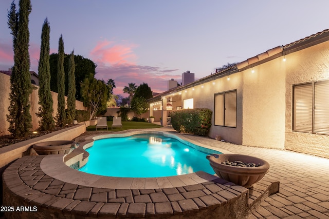 pool at dusk featuring a patio area