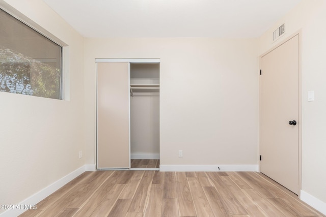 unfurnished bedroom featuring light wood-type flooring, baseboards, and visible vents