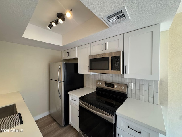 kitchen featuring light countertops, appliances with stainless steel finishes, visible vents, and white cabinets