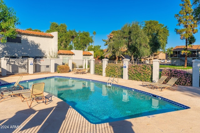 community pool featuring a patio area and fence