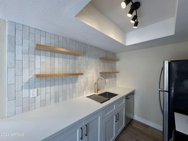 kitchen with stainless steel appliances, a sink, light countertops, open shelves, and tasteful backsplash