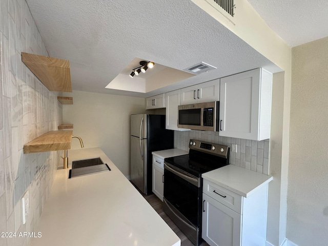 kitchen with stainless steel appliances, light countertops, visible vents, and white cabinetry