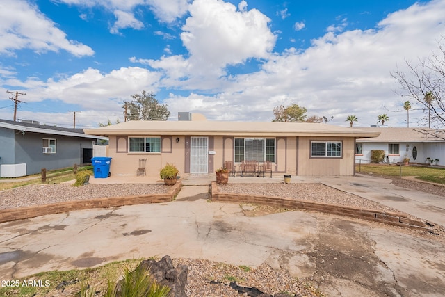 ranch-style house with concrete driveway and fence