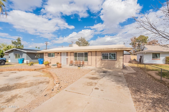 ranch-style house with concrete driveway, a patio, and fence