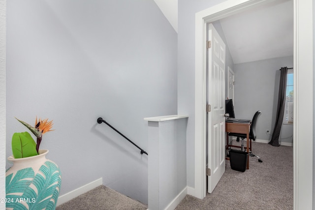 staircase featuring carpet flooring and vaulted ceiling