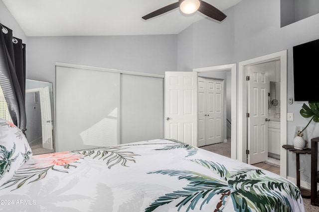 bedroom with ceiling fan, lofted ceiling, light carpet, and connected bathroom