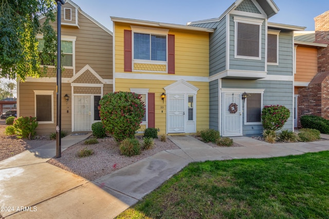 townhome / multi-family property featuring a front lawn