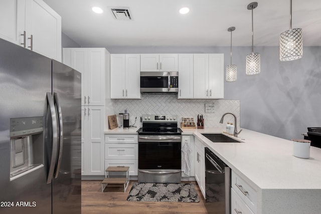 kitchen featuring white cabinets, hanging light fixtures, sink, and appliances with stainless steel finishes