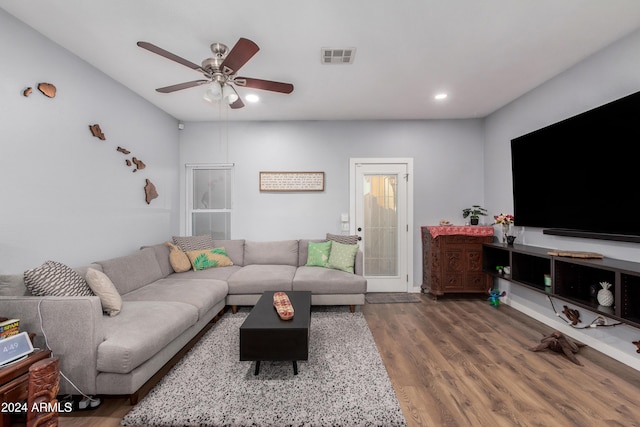 living room with ceiling fan and dark wood-type flooring