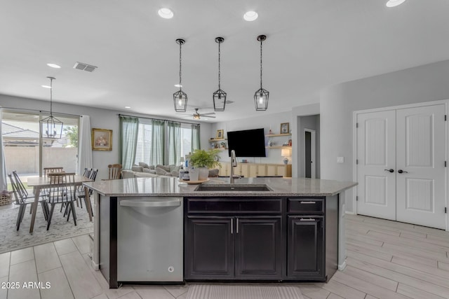 kitchen with visible vents, a kitchen island with sink, a sink, stainless steel dishwasher, and open floor plan