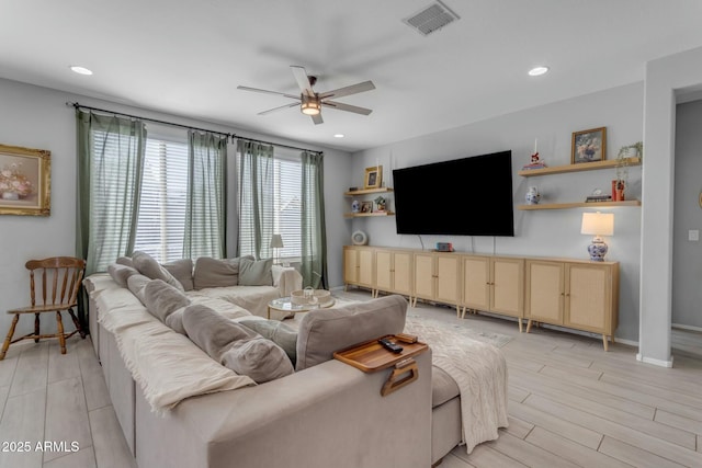 living area with recessed lighting, a ceiling fan, visible vents, and light wood finished floors