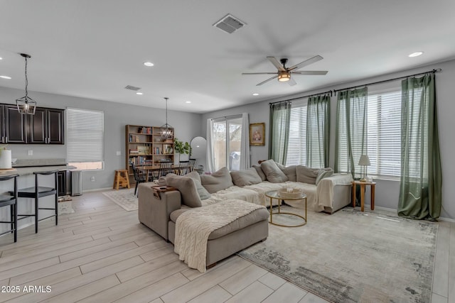 living room with recessed lighting, light wood-type flooring, visible vents, and ceiling fan