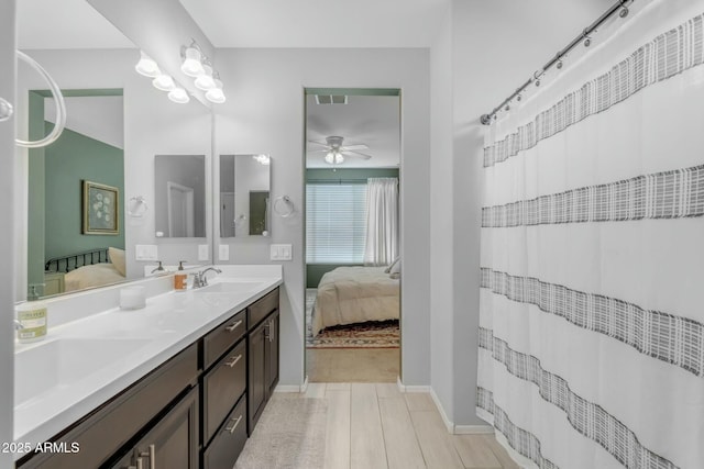 bathroom featuring double vanity, a ceiling fan, ensuite bathroom, and a sink