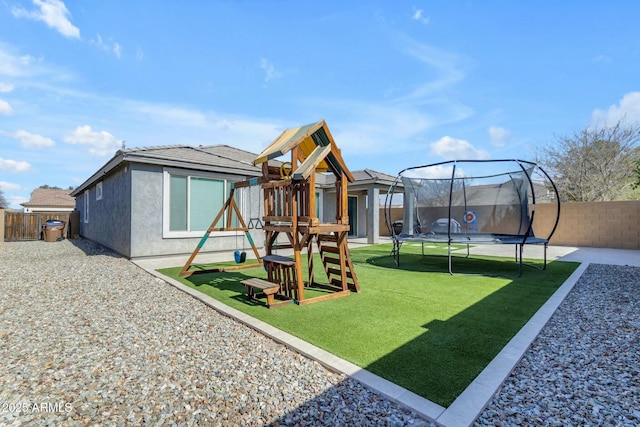 view of play area featuring a trampoline, a fenced backyard, and a lawn