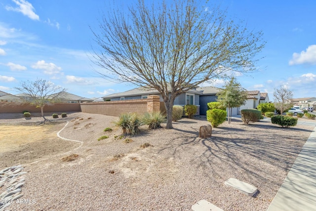 view of front of property featuring stucco siding, a residential view, and fence