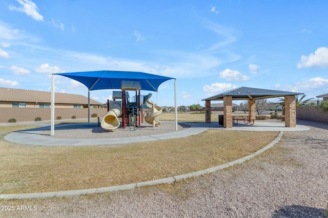 community play area featuring a yard and fence