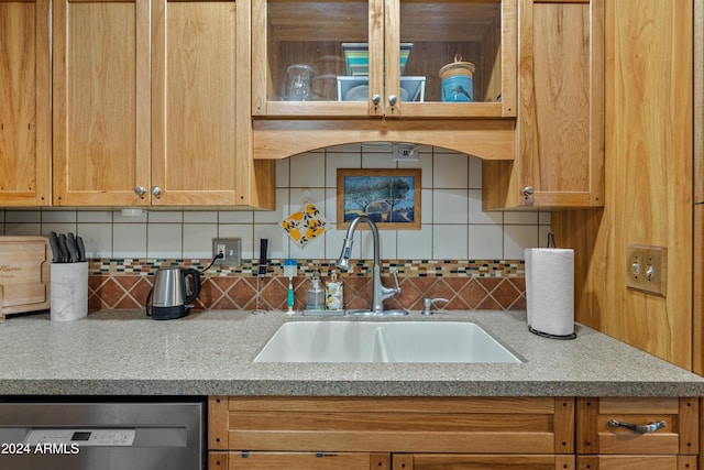 kitchen with black dishwasher, sink, and decorative backsplash