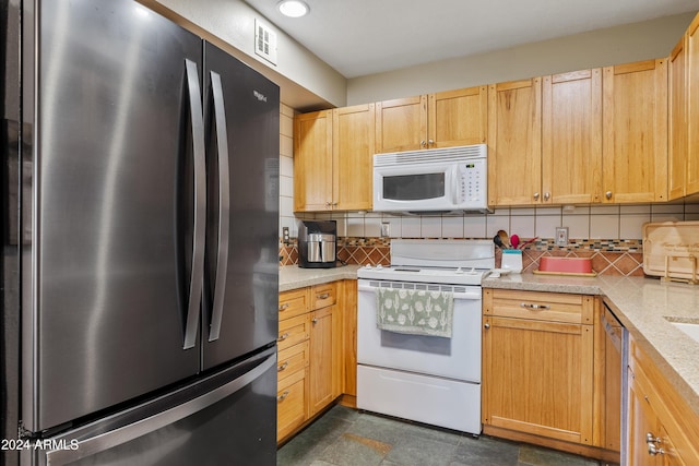 kitchen featuring backsplash, light brown cabinets, light stone countertops, and appliances with stainless steel finishes