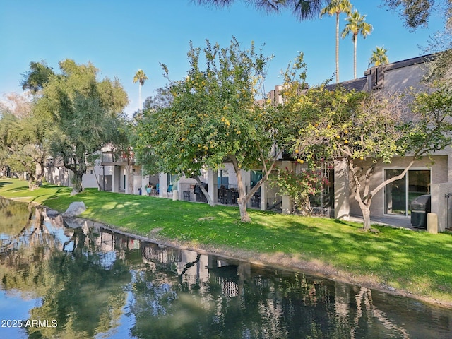 rear view of house with a lawn and a water view