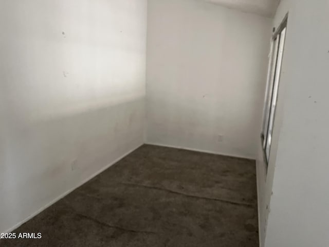 unfurnished room with dark carpet