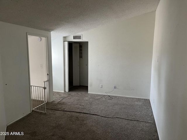 unfurnished room featuring carpet and a textured ceiling