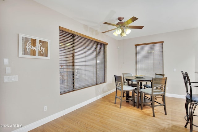 dining area featuring light wood-type flooring, ceiling fan, and baseboards