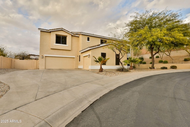 view of front of property featuring stucco siding, an attached garage, fence, driveway, and a tiled roof