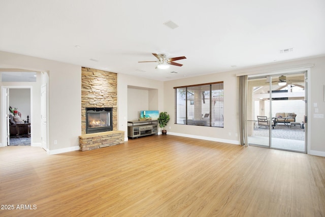 unfurnished living room featuring light wood-style floors, visible vents, a fireplace, and baseboards