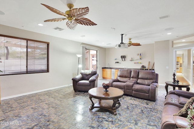 living area featuring a ceiling fan, visible vents, and baseboards