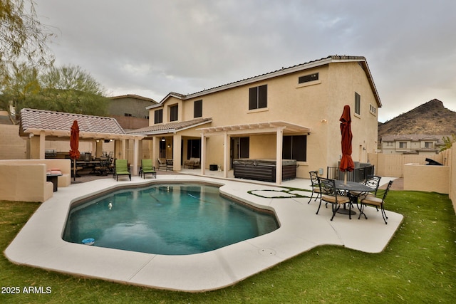 back of house featuring a patio, stucco siding, fence, a pergola, and a jacuzzi