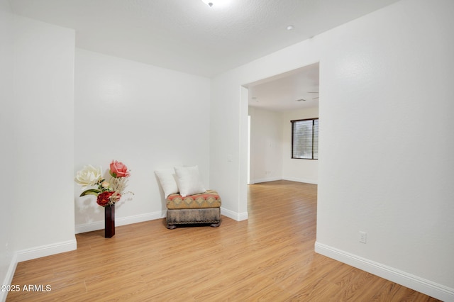 living area featuring light wood finished floors and baseboards