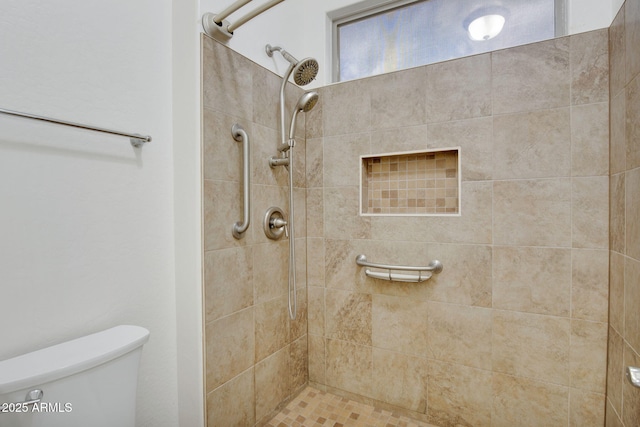 bathroom featuring toilet and a tile shower