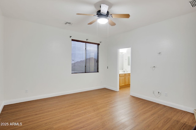 spare room with light wood-style flooring, visible vents, ceiling fan, and baseboards