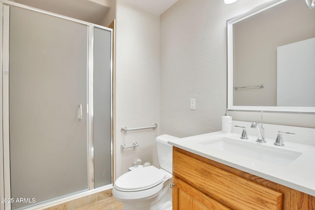 bathroom featuring vanity, a shower stall, and toilet