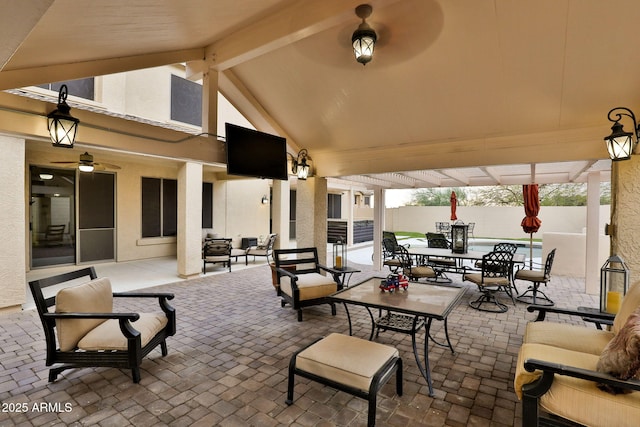 view of patio featuring outdoor dining area, fence, and an outdoor hangout area