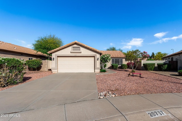 ranch-style house featuring fence, a garage, stucco siding, concrete driveway, and a tiled roof