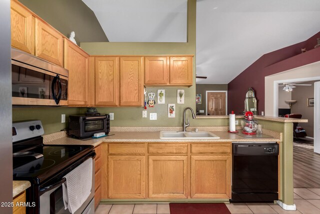 kitchen featuring a peninsula, ceiling fan, a sink, vaulted ceiling, and stainless steel appliances