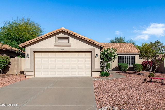 ranch-style home with stucco siding, concrete driveway, and a tiled roof