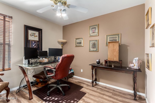 office featuring a ceiling fan, baseboards, and wood finished floors
