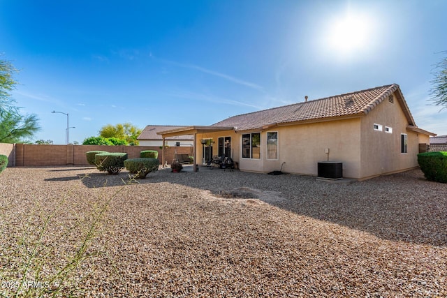 back of house featuring a patio, a fenced backyard, stucco siding, and a tiled roof