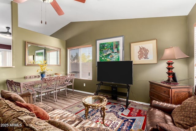 living room featuring baseboards, a ceiling fan, wood finished floors, and vaulted ceiling