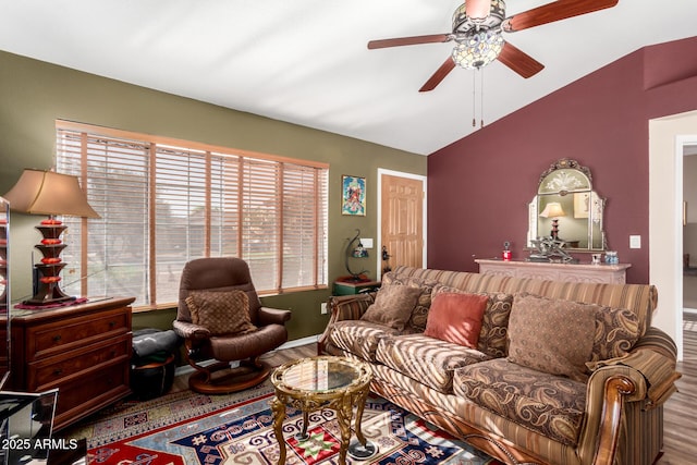 living area with ceiling fan, vaulted ceiling, and wood finished floors
