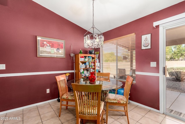 tiled dining space featuring a chandelier, baseboards, and vaulted ceiling