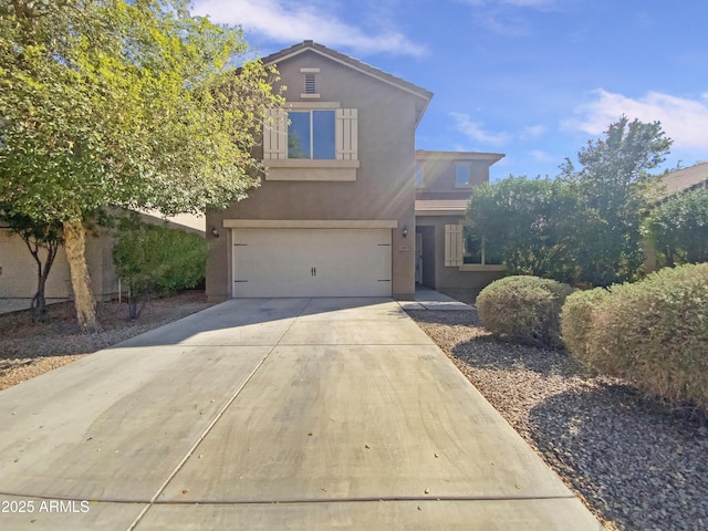 traditional-style house featuring stucco siding, driveway, and an attached garage