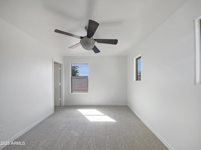 carpeted empty room featuring baseboards and ceiling fan