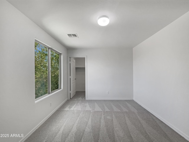 spare room featuring baseboards, visible vents, and carpet floors